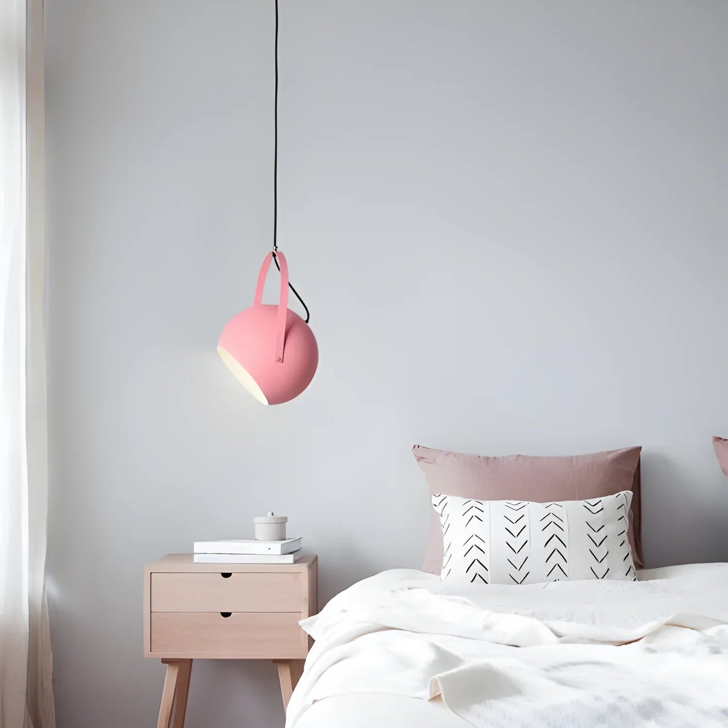 Pink pendant light hanging from a black cord