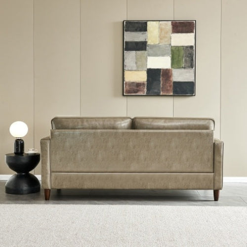 Modern mid-century khaki vegan leather sofa in a living room setting