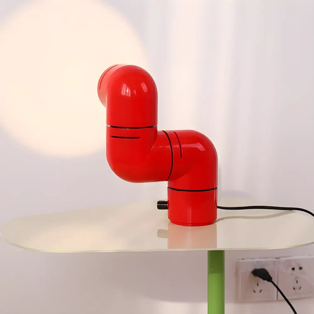 Red Space Age water pipe lamp on a table, showcasing a unique rotating design and modern minimalist style.